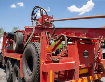 Close-up of red machinery against sky