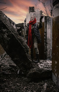 Rear view of man standing by building against sky