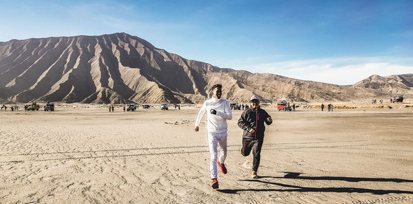 Rear view of people walking on mountain road