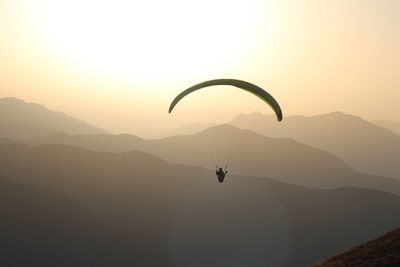 Low angle view of person paragliding against sky