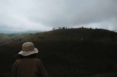 Rear view of woman looking at field against sky