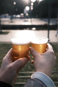 Close-up of hand holding beer glass