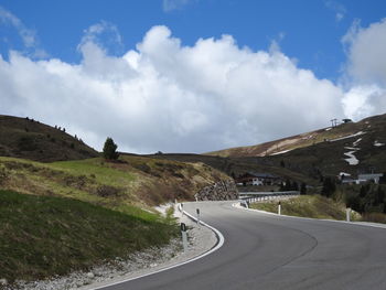 Empty road along landscape against sky