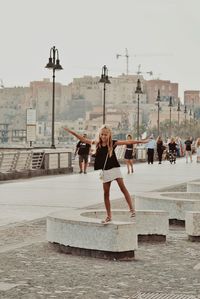 Woman with umbrella against clear sky in city