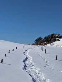 Scenic view of snow covered mountains against clear blue sky