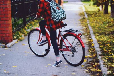 Low section of man riding bicycle on road