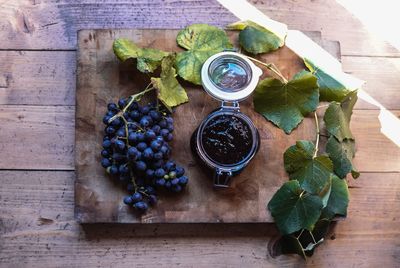 High angle view of fresh blueberries and preserves on cutting board