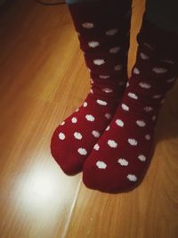 Low section of person wearing shoes on hardwood floor