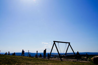 People on field against blue sky