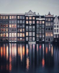 Reflection of buildings on river against sky