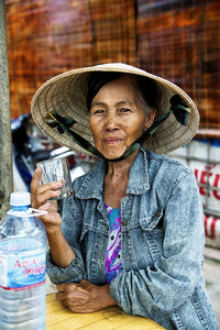 Portrait of woman wearing hat sitting outdoors