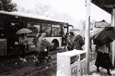 People on wet street in city during rainy season