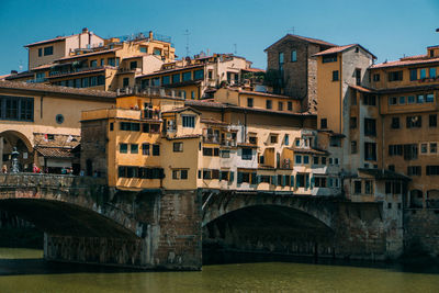 Bridge over river against buildings in city