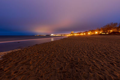 Surface level of beach against sky at night