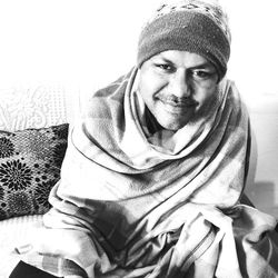Portrait of smiling young man sitting on sofa at home