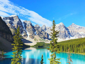 Scenic view of lake and mountains against blue sky