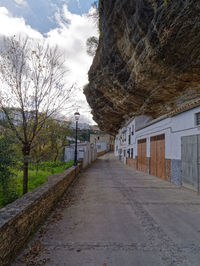 Empty road amidst buildings against sky