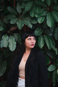 Dark-haired female model in vintage clothing and make-up against a colorful wall.