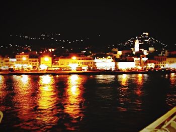 Illuminated bridge over river at night