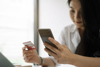 Midsection of woman using mobile phone