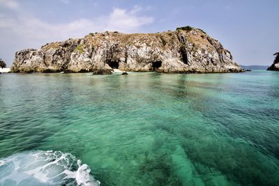 Rock formation in sea against sky