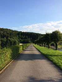 Road amidst trees against sky