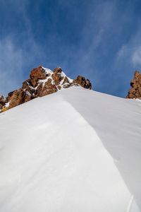 Low angle view of snowcapped mountain against sky
