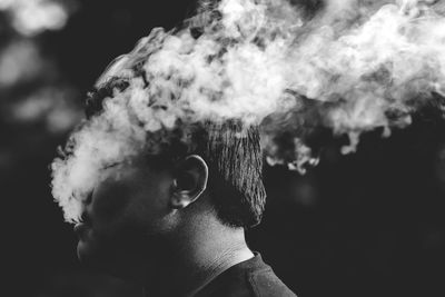 Close-up portrait of young man smoking outdoors