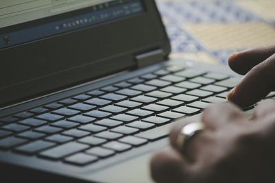 Cropped hands using laptop on table