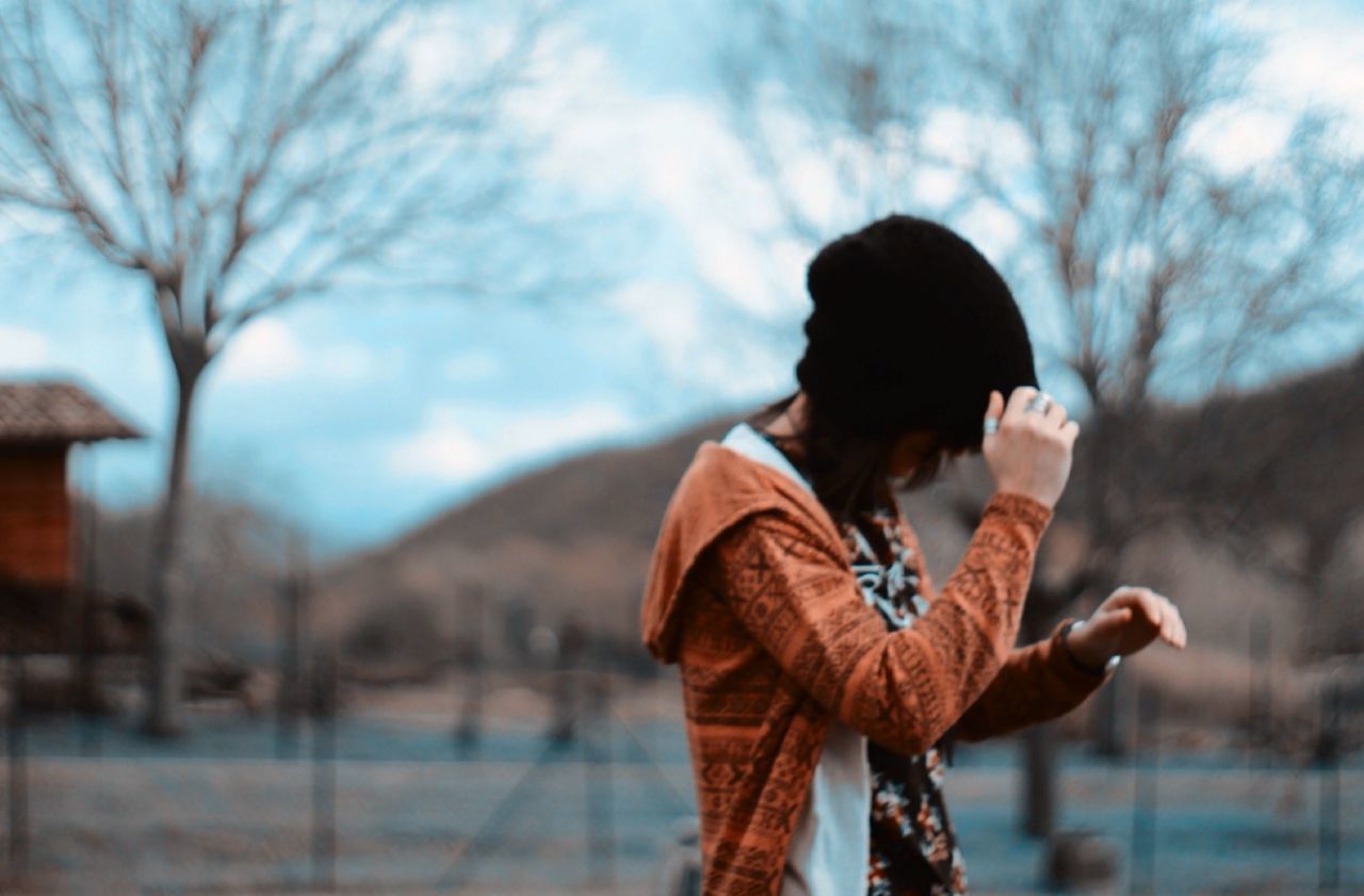 Side view of girl in warm clothing against blur background