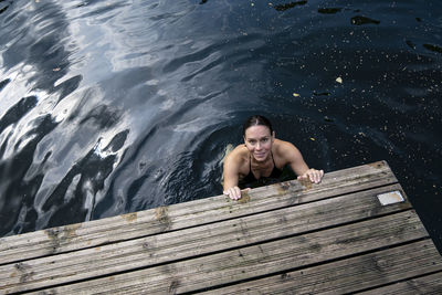 High angle view of shirtless man swimming on pier