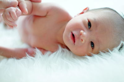 Close-up of cropped hand holding baby sleeping on fur