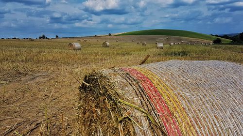 Hay bales on field against sky