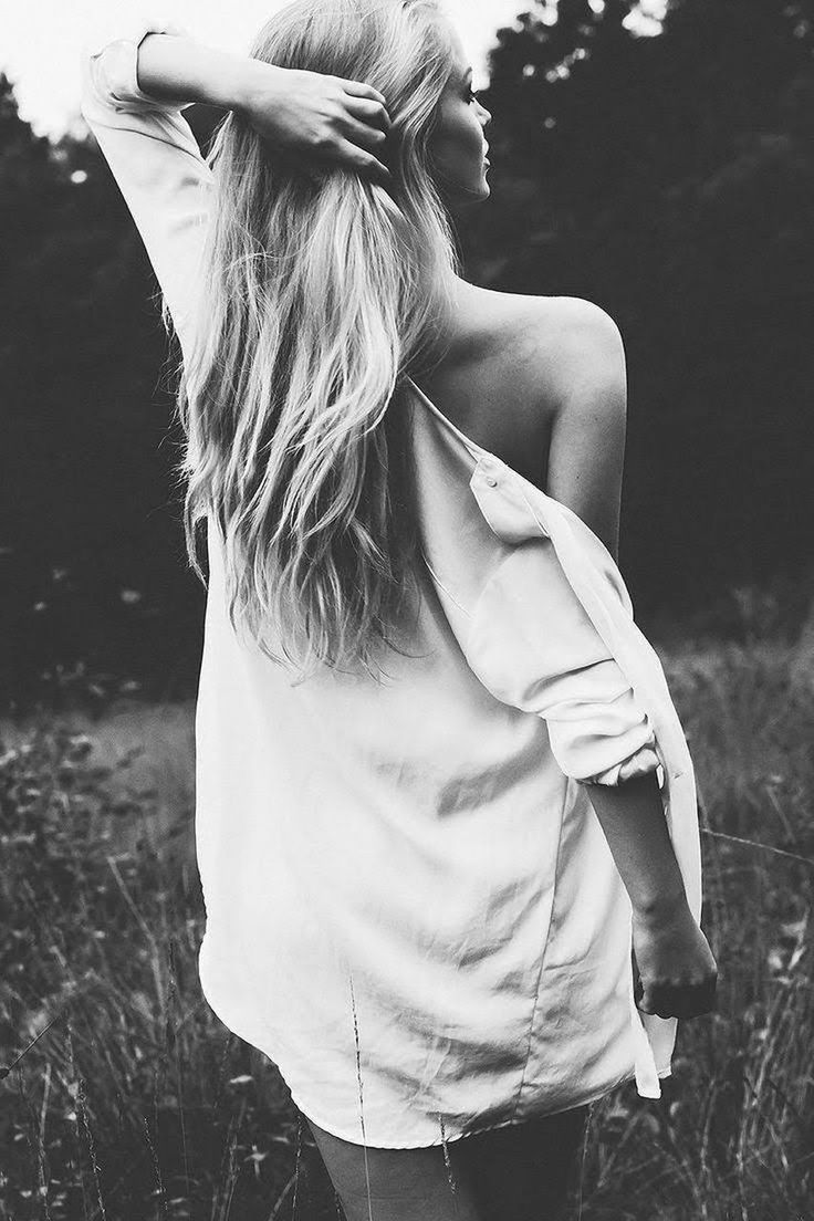 REAR VIEW OF WOMAN STANDING ON FIELD DURING RAINY DAY