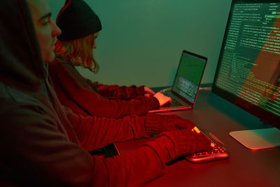 Side view of woman using laptop at home