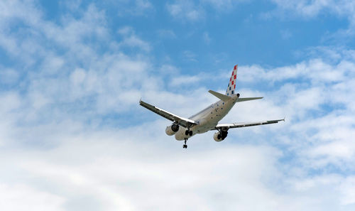 Low angle view of airplane flying against sky