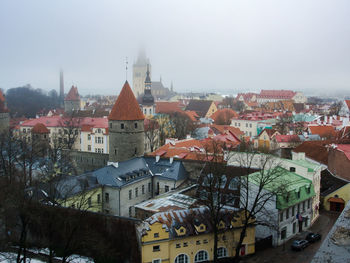 Houses in city against sky during winter