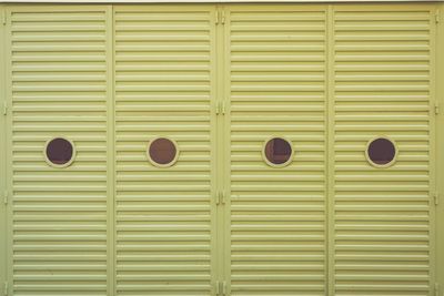 Round windows portholes on green garage door 