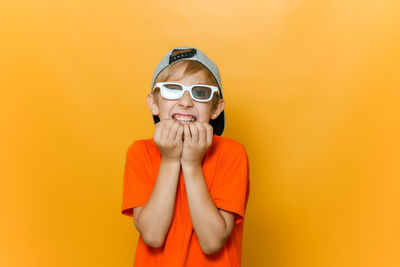 Portrait of boy wearing sunglasses against yellow background