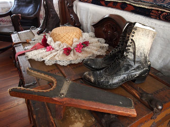 High angle view of hat amidst antique boots on treasure chest