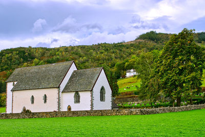Kvinnherad church among the green hills and grazing animals 