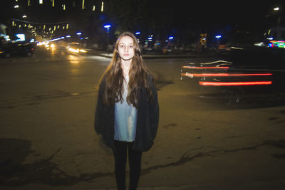 Double exposure of light trails and teenage girl in city at night