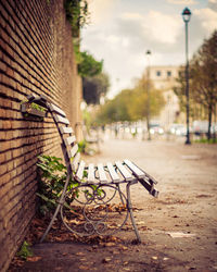 Empty bench against wall in city