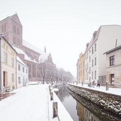 Snow covered city against clear sky