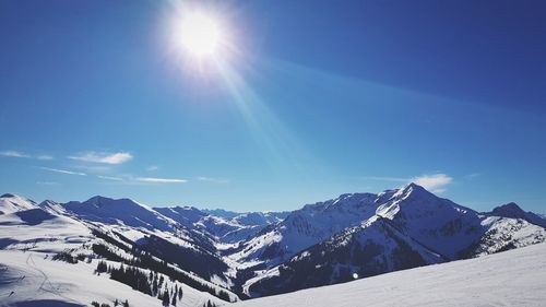 Scenic view of snowcapped mountains against blue sky