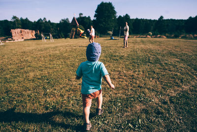 Rear view of children playing on field