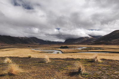 Scenic view of land and mountains against sky