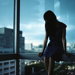 Solitary young woman looking down indoors