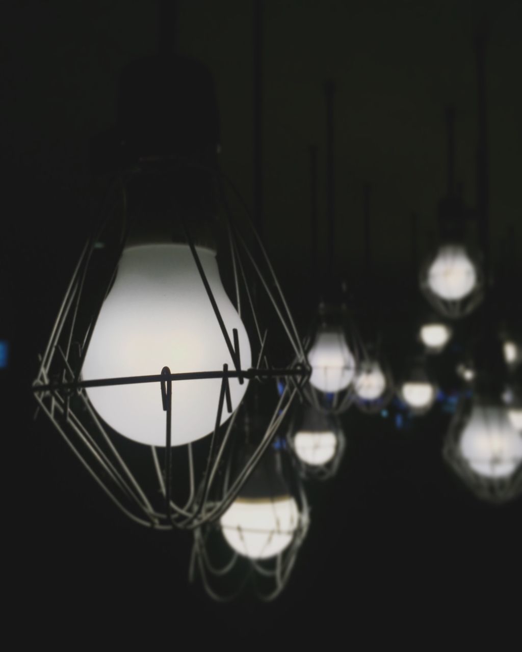 hanging, illuminated, no people, electricity, indoors, close-up, night, black background