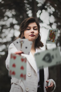 Young woman looking away while standing on tree